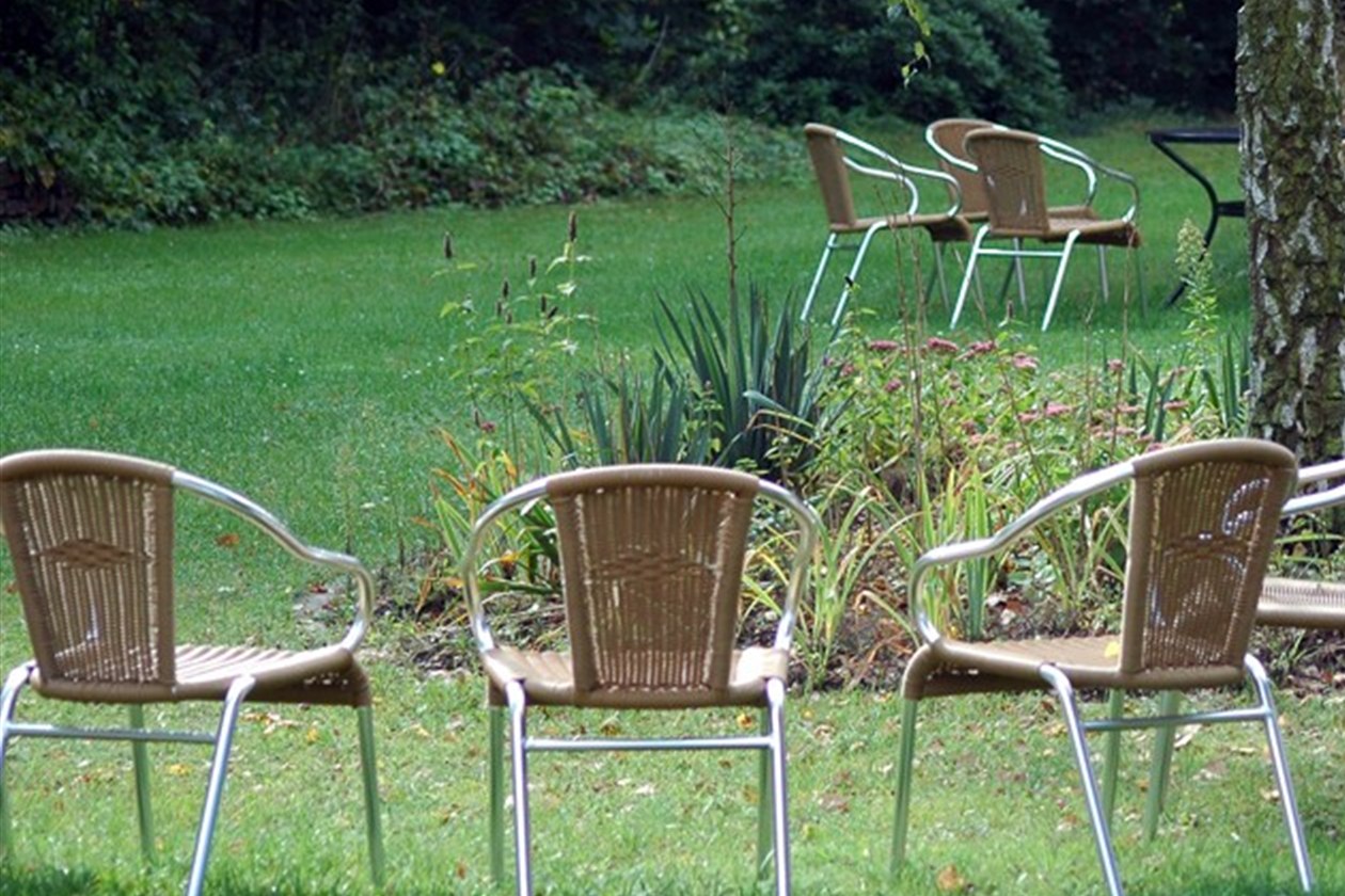 Lege stoelen in een tuin, samen een groep en toch elk met een eigen plek