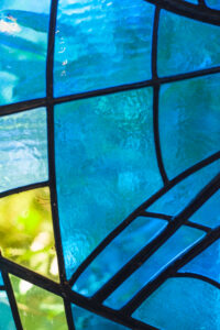 Detail van het blauw-groene glas-in-loodraam van de kapel