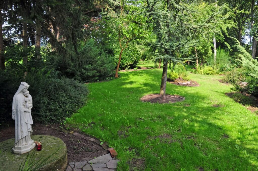 Mariabeeld links, met de blik de lichte tuin in geleid